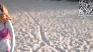 Девушка в шортах у воды на песке