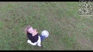 Юная девушка в порывах ветра на траве.