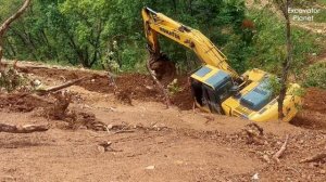 Экскаватор Hyundai 220S пробивает дорогу через гору.