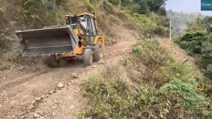 Восстановление дороги в скалистых горах после оползня с помощью экскаватора-погрузчика JCB.
