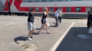 Коллектив девушек танцует на железнодорожной платформе