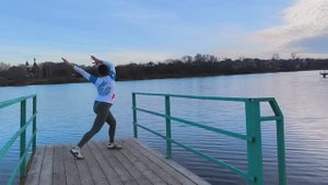 Баланс у озера на мостике, образующего в воде волны сбалансированности