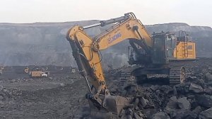 Экскаватор XCMG 870 GK загружает твердый грунт в самосвалы Volvo.