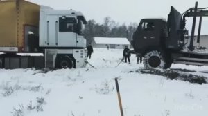 Камаз вытаскивает гружёную фуру из снега