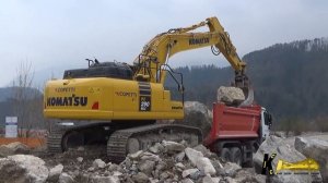 Экскаватор KOMATSU PC 290 11 загружает камни в грузовик.