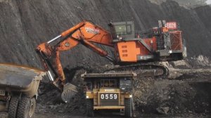 Экскаватор Hitachi EX2600 Загружает вскрышные породы на самосвалы Komatsu и Caterpillar