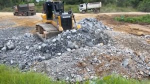 Бульдозер Shantui DH17 C3, который толкает камни в глубокую зону.