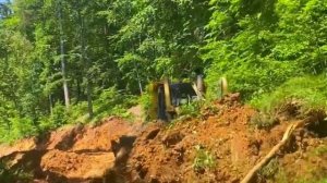 Опытный оператор бульдозера строит дорогу.