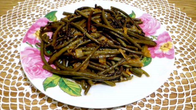 тарелка с приготовленным папоротником орляк