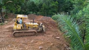 Бульдозер D41P толкает камни к фермерскому домику.