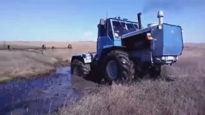 Трактор Т-150К преодолевает канаву с водой