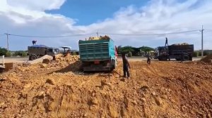 Бульдозер и Экскаватор засыпают бетонную дренажную систему.