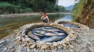 Молодая девушка ловит рыбу очень простым способом. Примитивная ловушка из камней