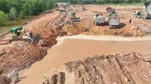 Бульдозеры толкают камни и почву, заполняя провалившуюся территорию с помощью сотни самосвалов.