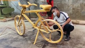 Мужчина строит велосипед из дерева.