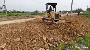 Грузовики и бульдозер засыпают болотистые участки.