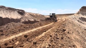 Бульдозер Caterpillar D8T и роторный экскаватор работают вместе.