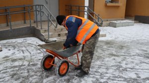 Ноябрьский гололед: дворники посыпают тротуары рядом с домами песком