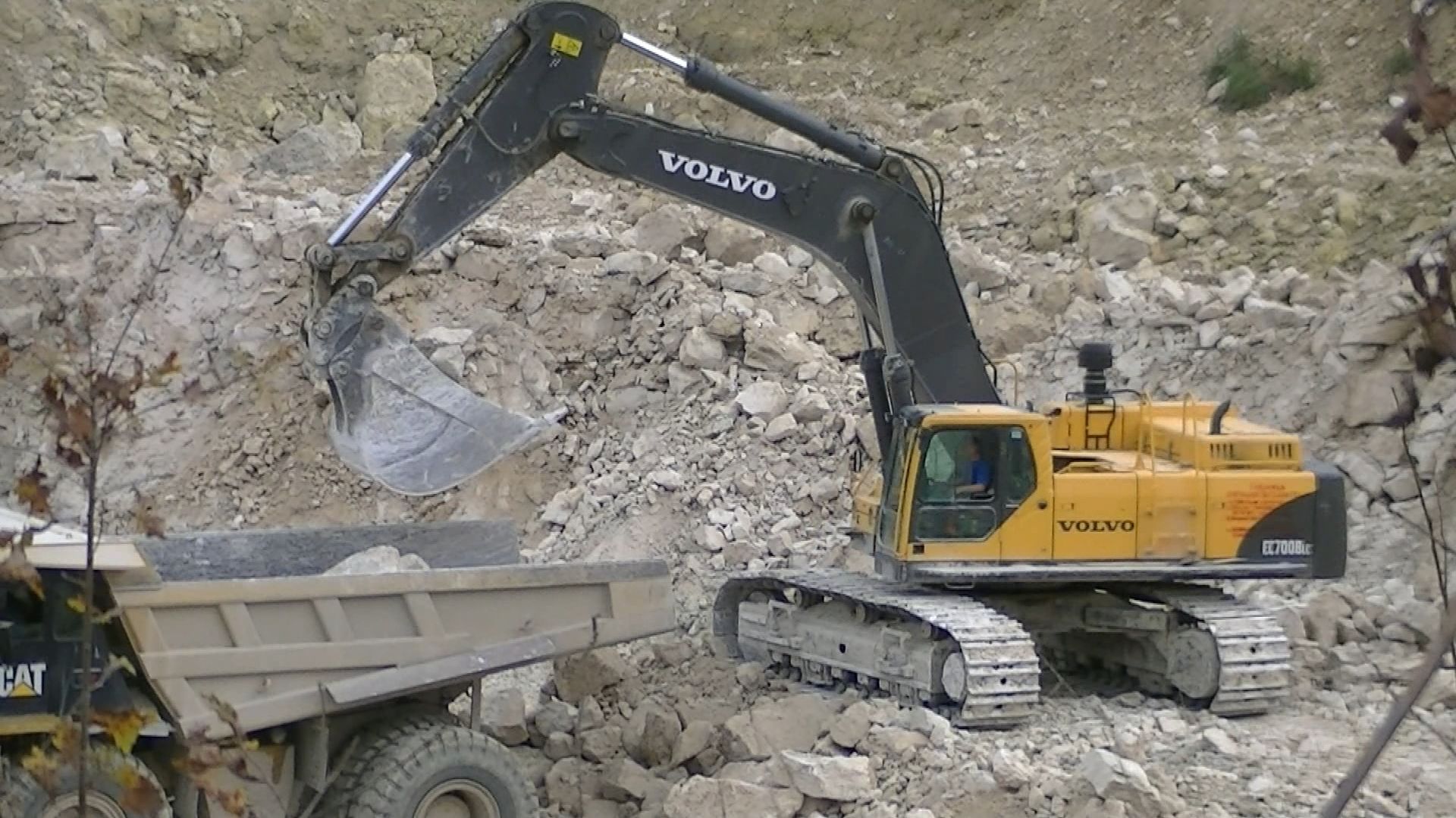 Экскаватор Volvo EC700B LC грузит самосвалы в карьере смотреть онлайн