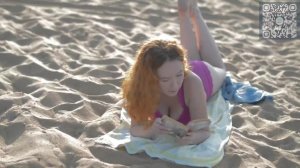 Красивая девушка загорает на песке. A beautiful girl sunbathes on the sand.