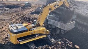 Экскаватор Cat 390D Загружает вскрышные породы на 4-Осные самосвалы