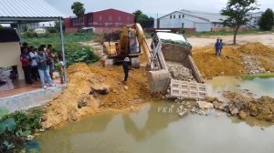 Грузовик терпит неудачу при выгрузке камня, а экскаватор и бульдозер помогают ему.