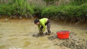Девушка руками ловит угрей для продажи на рынке.