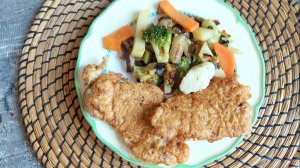 Сочные румяные отбитые пластики свинины с жареным гарниром из цветной капусты, брокколи, баклажанов.