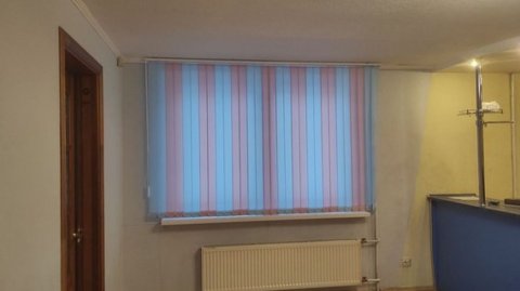 Вертикальные жалюзи с чередованием ламелей создали оригинальный декор окнам в комнате.