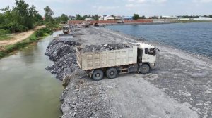 Отличная работа!! Бульдозер Shantui толкает камень, который выгружают самосвалы.