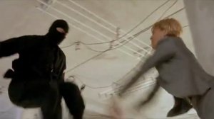 Эмильен угрожает бандитам пистолетом, но Юли и Петра используя приемы джиу-джитсу