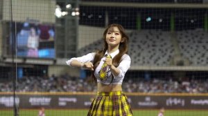 Красивая японская девушка пляшет на поле перед матчем.
