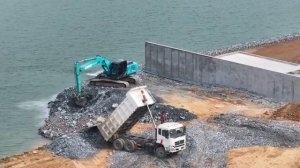 Грузовики загружают большие камни в озеро, а экскаваторы выкапывают камни 💥