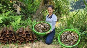 Девушка ловит рыбу в корзины из бамбука.