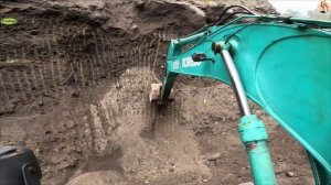 Строительство, экскаватор копает песок