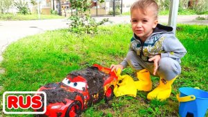 Никита играет в автомойку с красной детской машинкой.