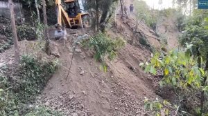 Сельские горные поселки соединены новой узкой дорогой с экскаватором JCB