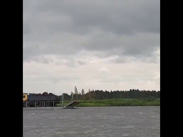 Самоходный паром с грузовиком уверенно движется по реке