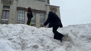 Студенты катаются на большом сугробе в центре Москвы