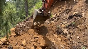 Excavator Backhoe Cutting Rocky Hillside to Build a Narrow Mountain Road – 3