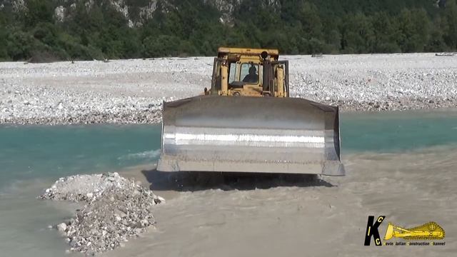 Бульдозер Caterpillar D9N копает гравий в воде. смотреть онлайн