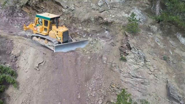 CAT D7 BULLDOZER пробивает дорогу в опасном месте в горах. смотреть онлайн