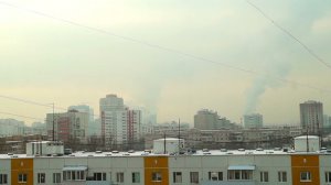 Город в дымке. Вид с балкона на многоэтажки и дым из труб