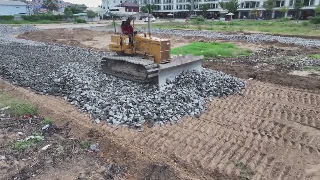 Строительство дороги. Бульдозеры разравнивают камни, которые привозят самосвалами смотреть онлайн