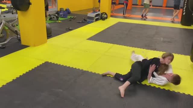 Девочка победила парня на тренировке по Джиу-джитсу. A girl defeated a guy in a Jiu-jitsu.