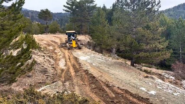 Горные дороги который ремонтирует автогрейдер John Deere 670