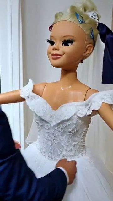 Кукла одевает свадебное платье