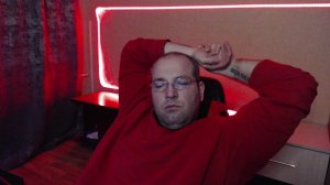 сижу и смотрю в камеру в красном свитере