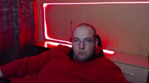 сижу и смотрю в камеру в красном свитере