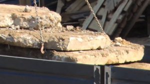 Грузовик с краном манипулятором выгружает плиты на стройке